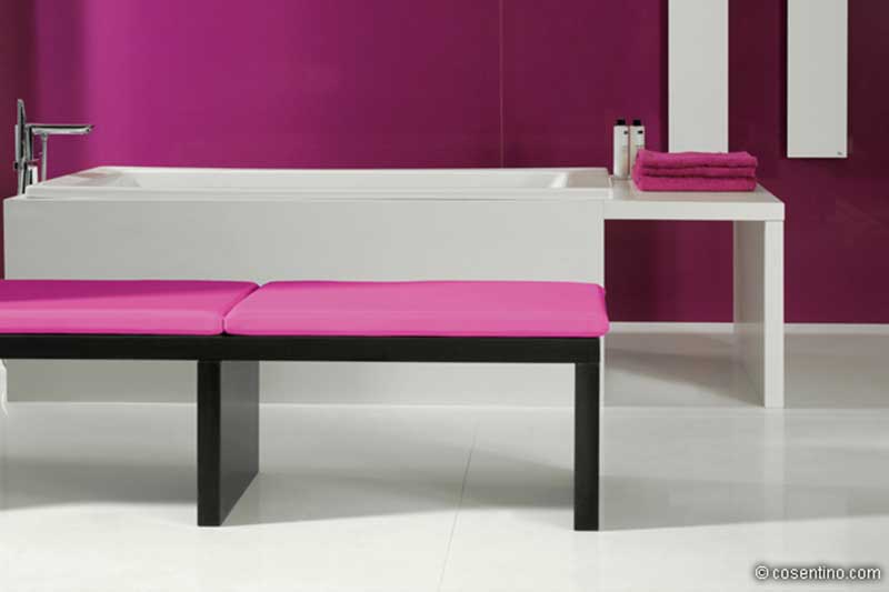 Weiße Badewanne auf Dekton mit pinker Badezimmer Wand